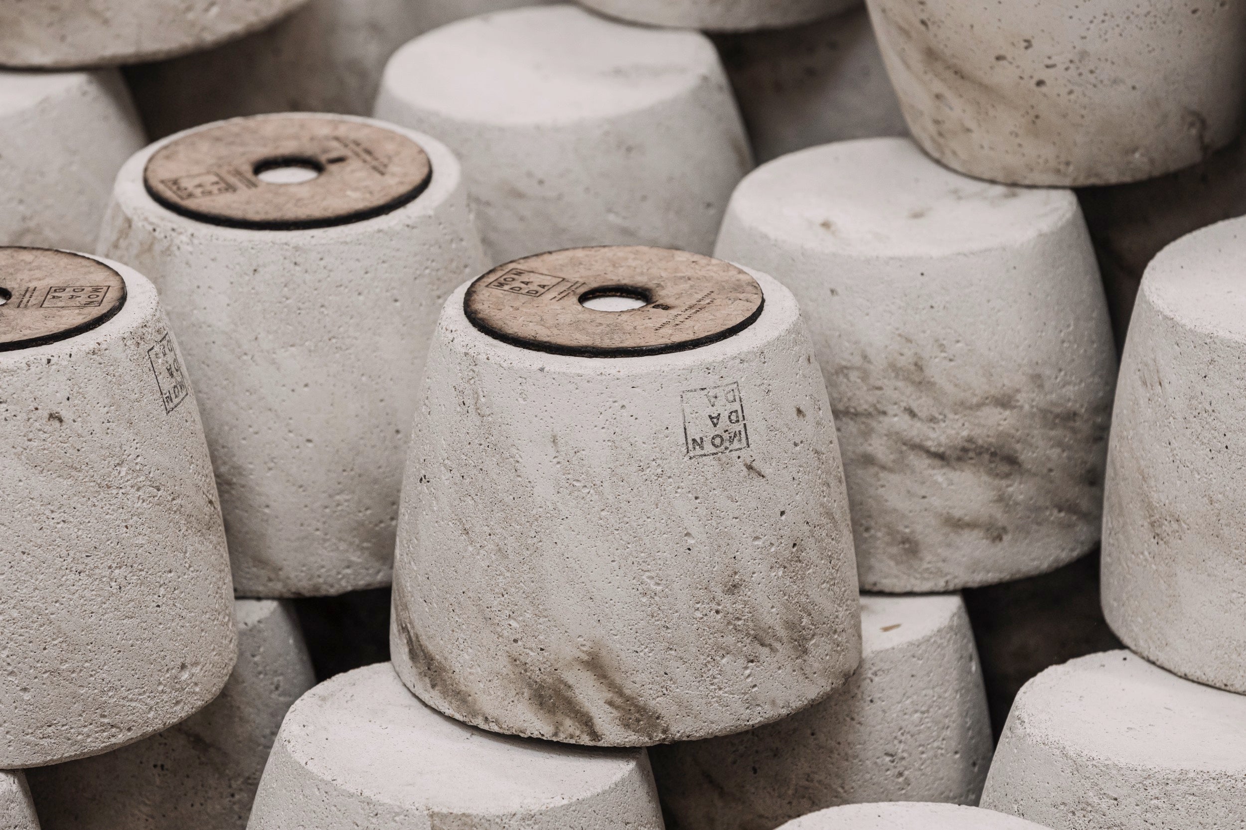 Concrete candle pots manufactured in Belgium. They are stacked on each other.